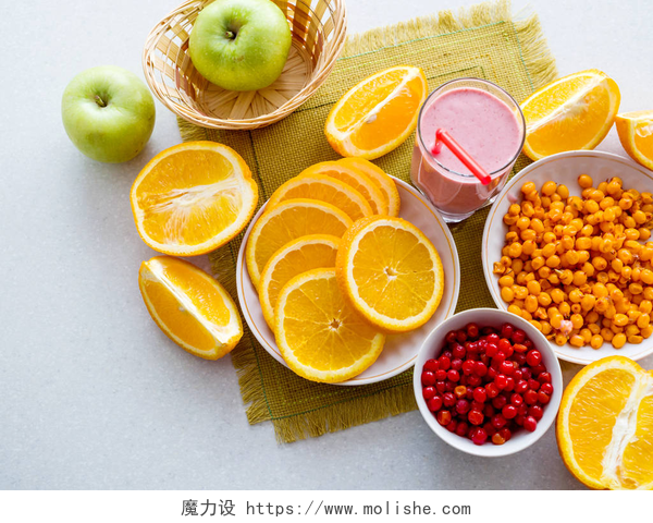 在白色的桌子上有不同种类的水果在桌子上切下多汁的橘子和浆果鸡尾酒。从上面看